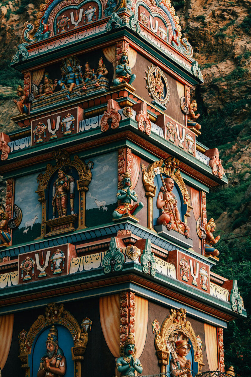 Intricately decorated Himalayan temple tower with colorful carvings and statues, reflecting rich cultural heritage.
