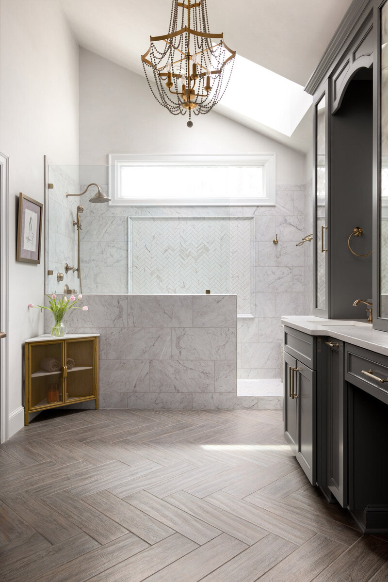 Bathroom redesigned with marble shower and herringbone floors.