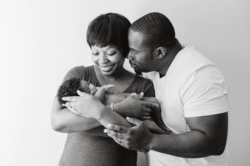 African American family embracing and holding their newborn baby