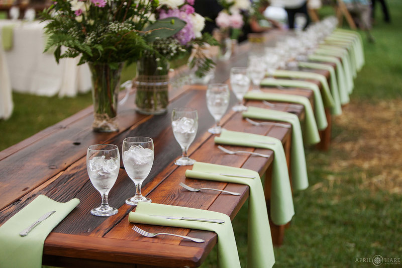 Long wood tables set up for a wedding at Riverbend wedding venue in the white tent at Riverbend
