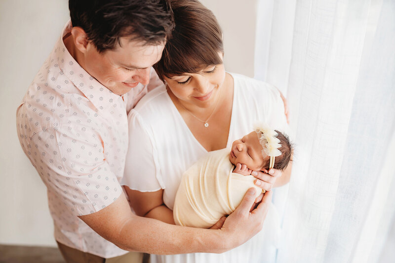 New parents pose with their infant during Newborn Portrait Session in Asheville, NC.