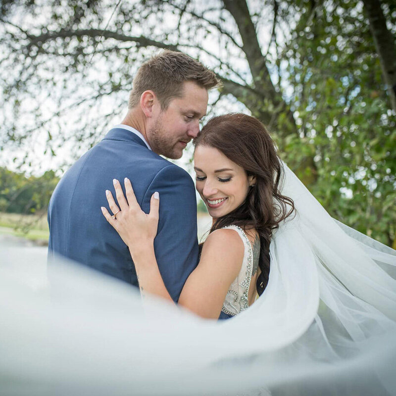bride and groom with her veil blowing toward the camera