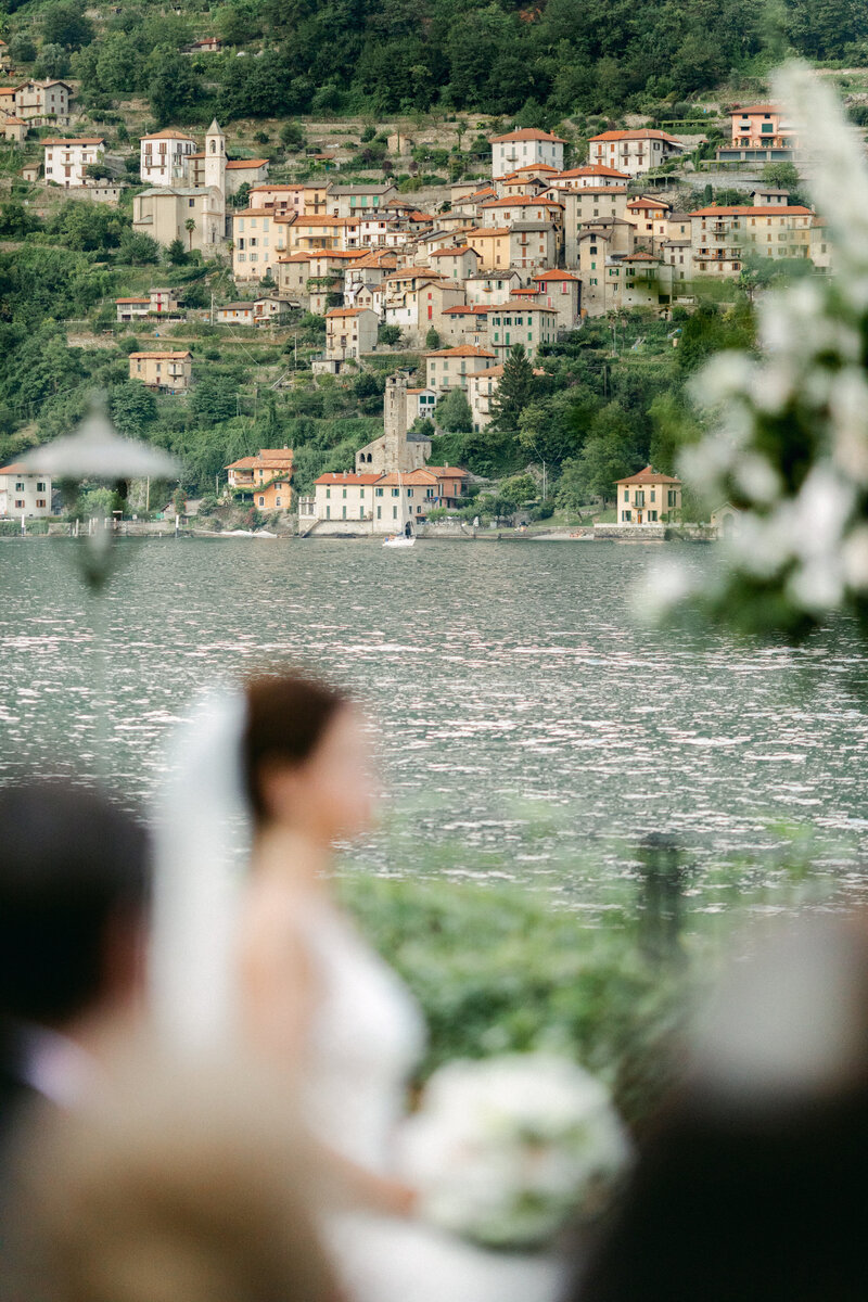 Italian church on the shore on Lake Como with green mountain and blue sky behind