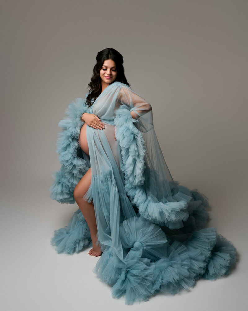 Studio maternity robe in soft blue with dramatic ruffled trim and sheer sleeves – worn open over undergarments
