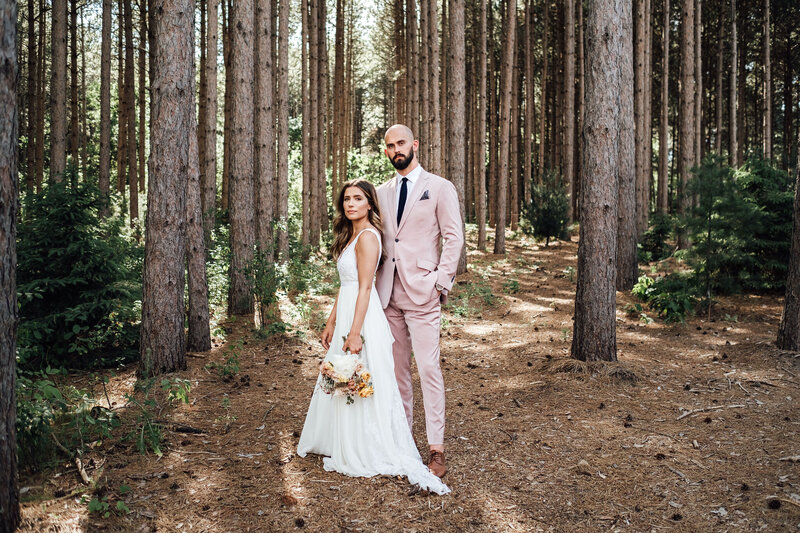 Bride and groom standing in front of trees