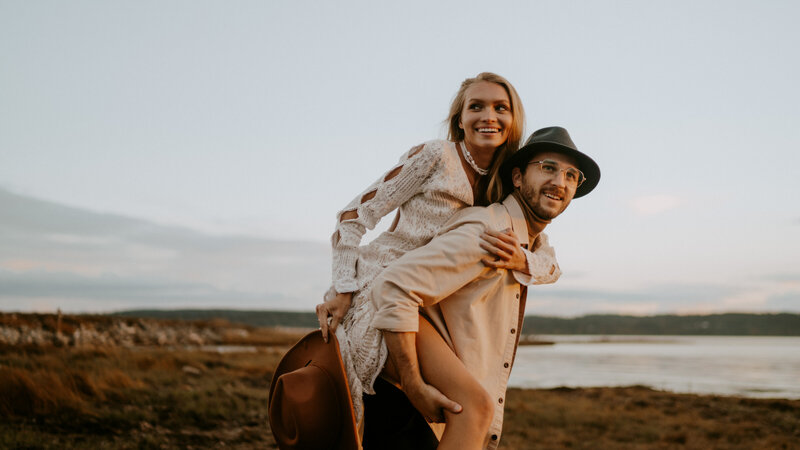 Bride and Groom in field during golden hour sunset in boho styled dress and suit