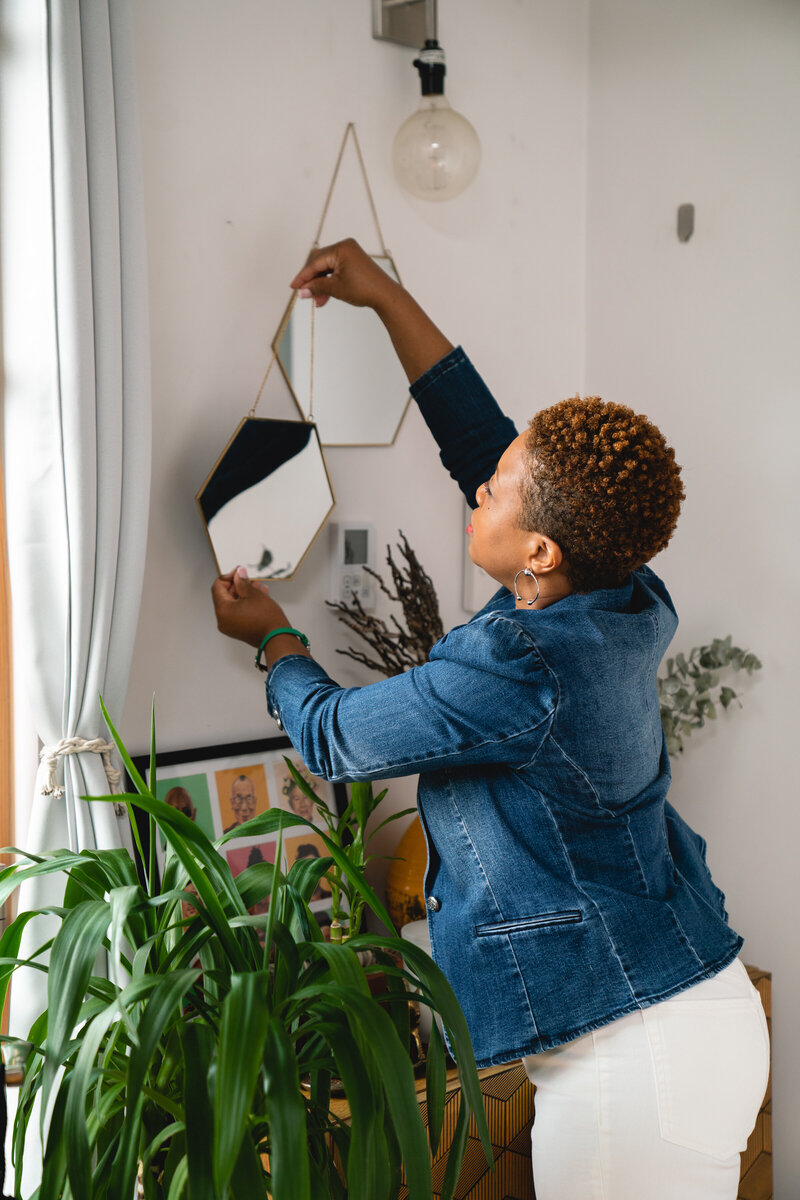Michelle hanging a mirror on the wall