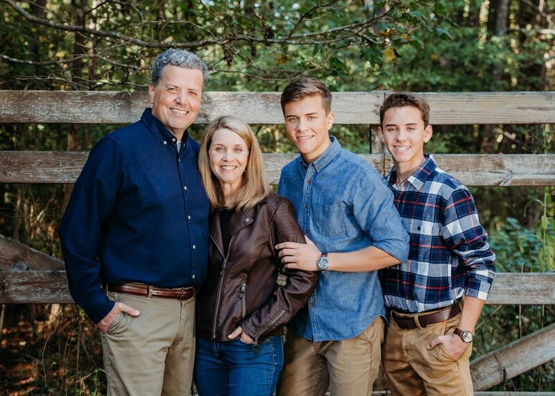Family portrait in front of a wooden fence in Peachtree City, Georgia