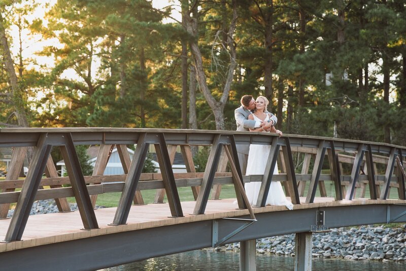 Bride and Groom embrace on a bridge