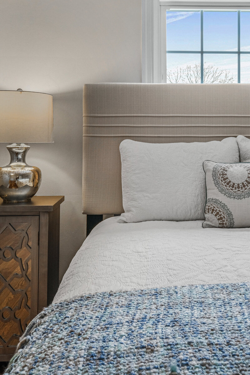 Close up of a staged bedroom with cozy decor and pillows