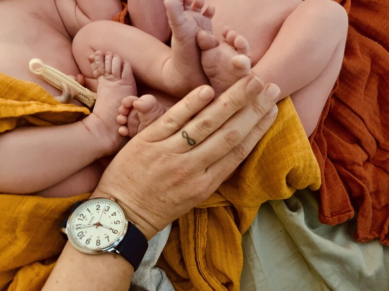 Two women playing with a baby in a field
