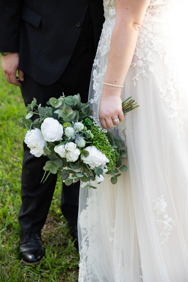 A bride and groom posing with their wedding bouquet captured by an Austin wedding photographer.