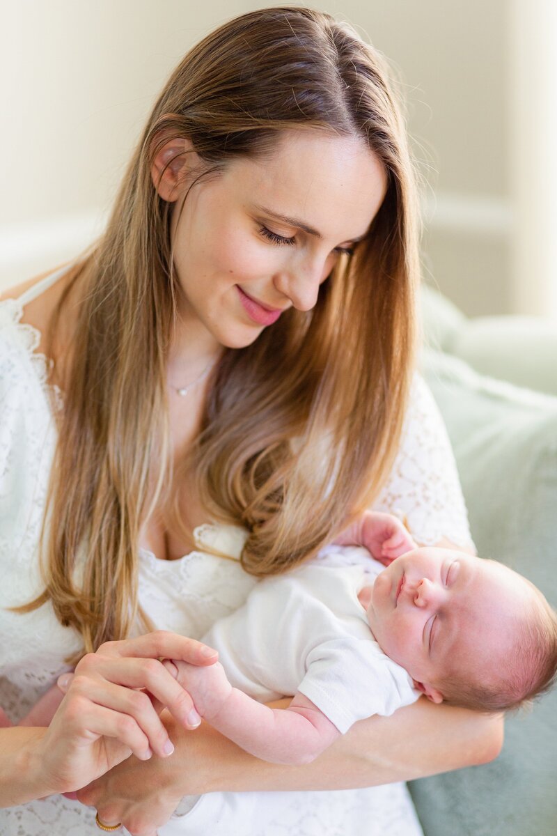 mom with long luxurious hair holds her sleeping baby