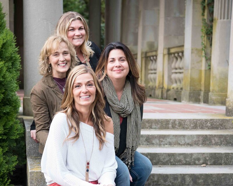 Adult sisters sitting on steps with their mother
