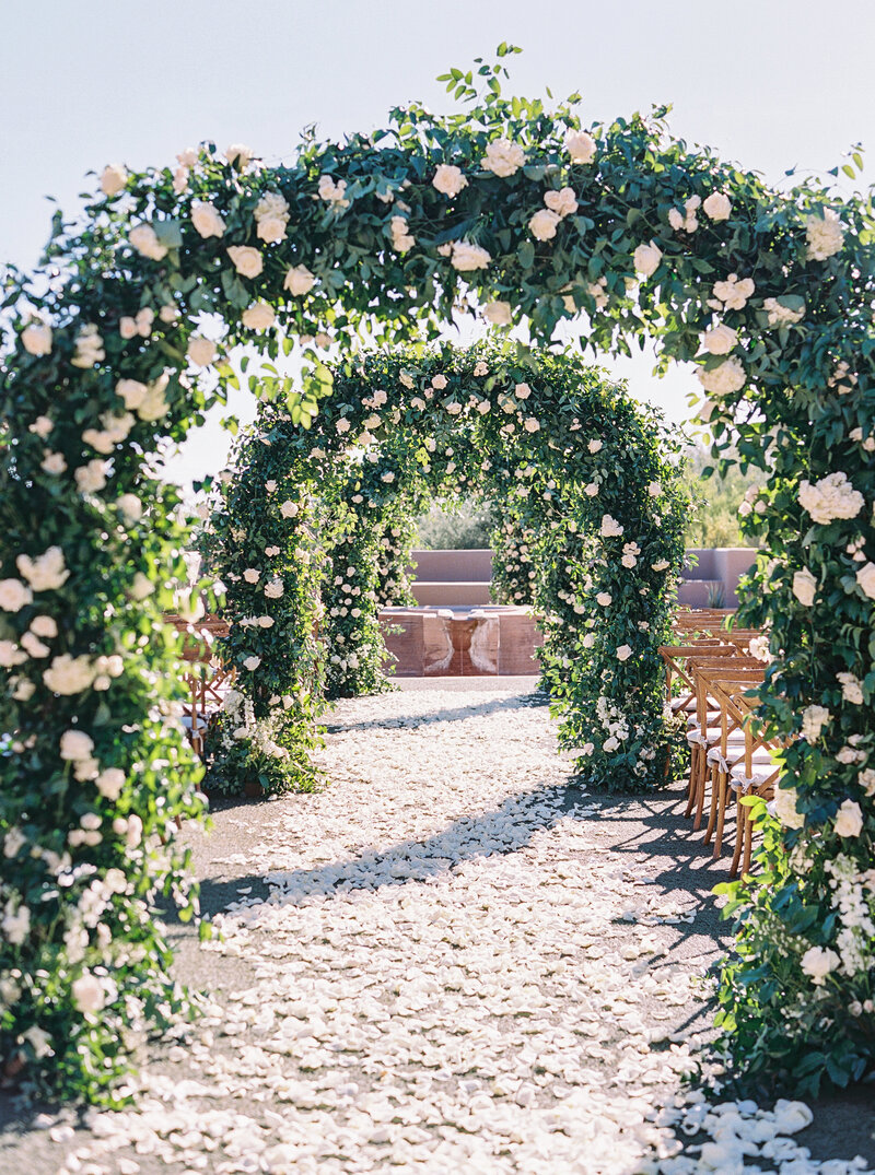 Fine art wedding photography showcasing an elegant floral aisle leading to a luxury wedding ceremony, with stunning floral arrangements and natural beauty.
