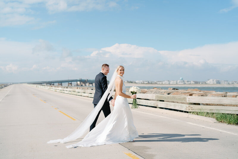Bride and groom walking on the beach during portraits in Cape May, New Jersey
