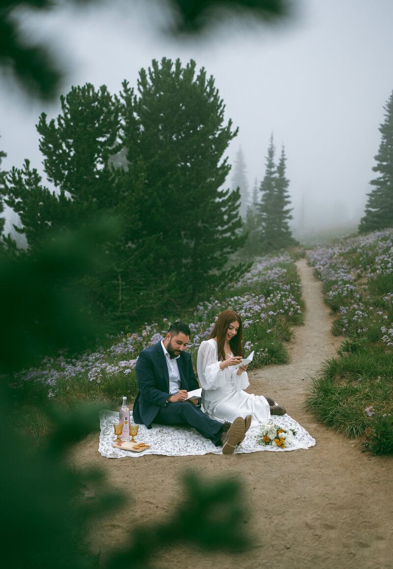 Mt. Rainier elopement couple at Silver Forest trail writing their vows.