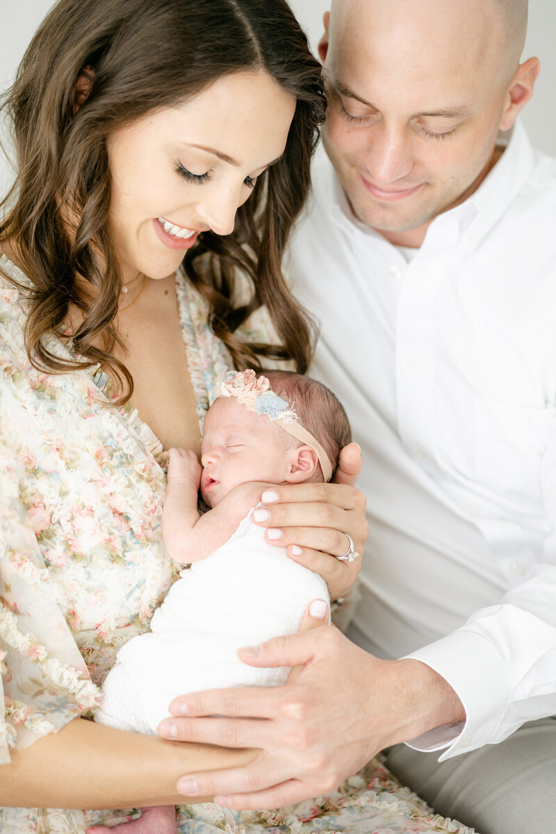 parents holding their newborn baby girl