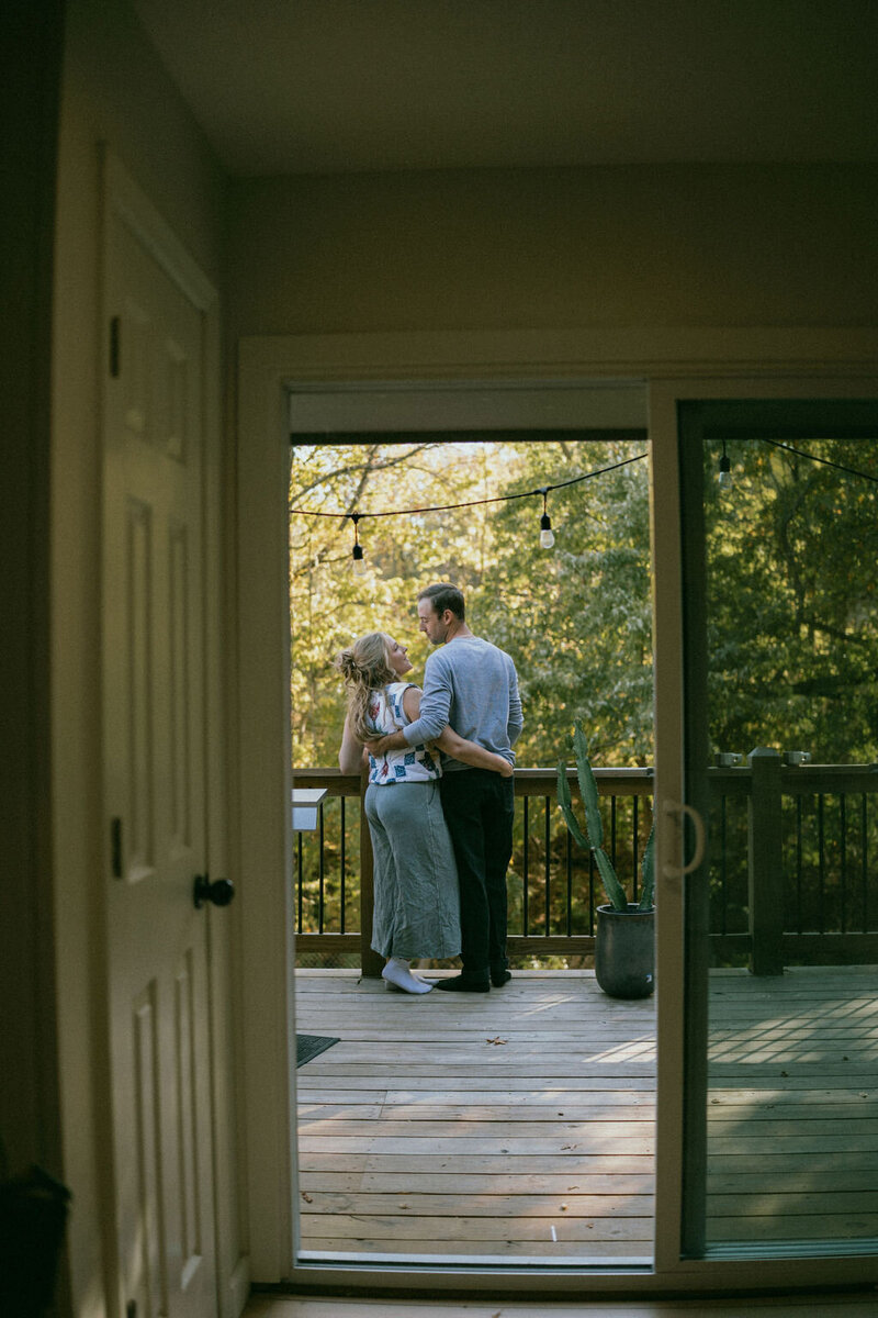 Couple embraces on the deck of a porch