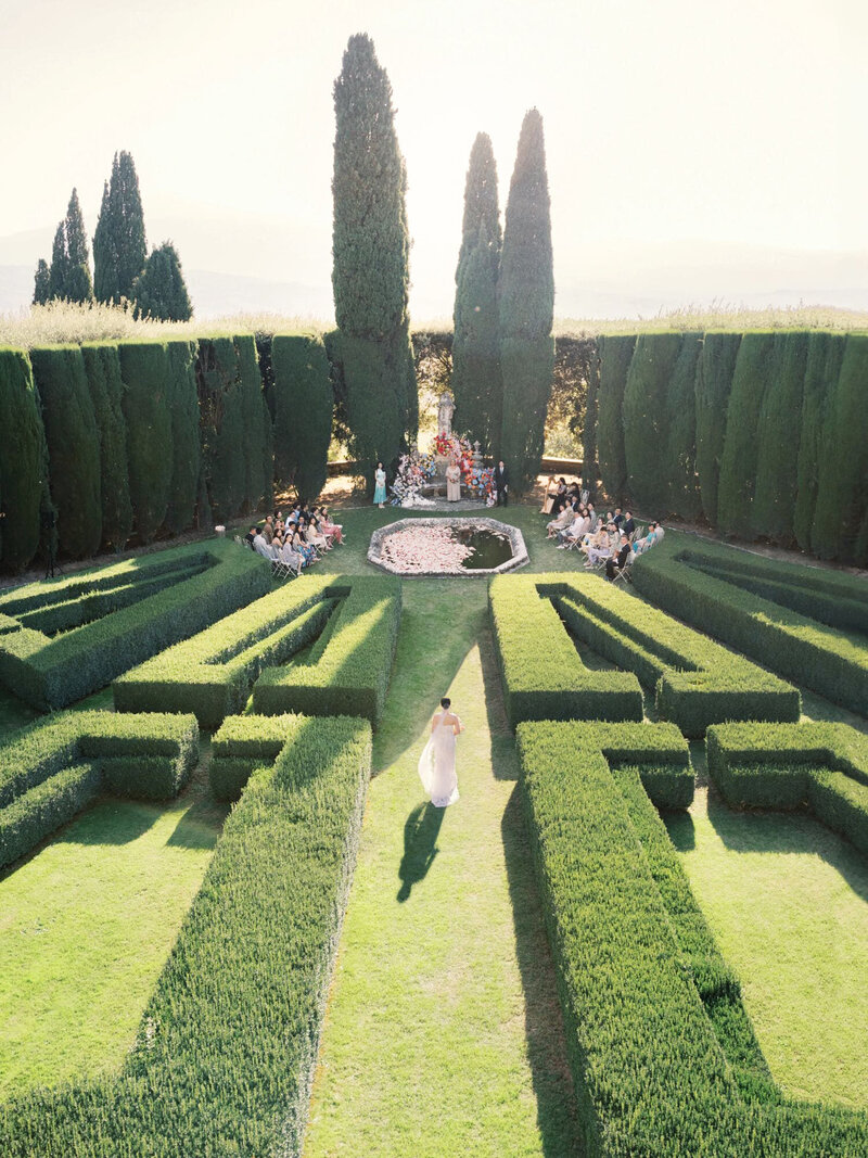 Bride walking down the isle in La Foce, in the Renaissance garden, with guests in the background, cptured by Andreas K. Georgiou 