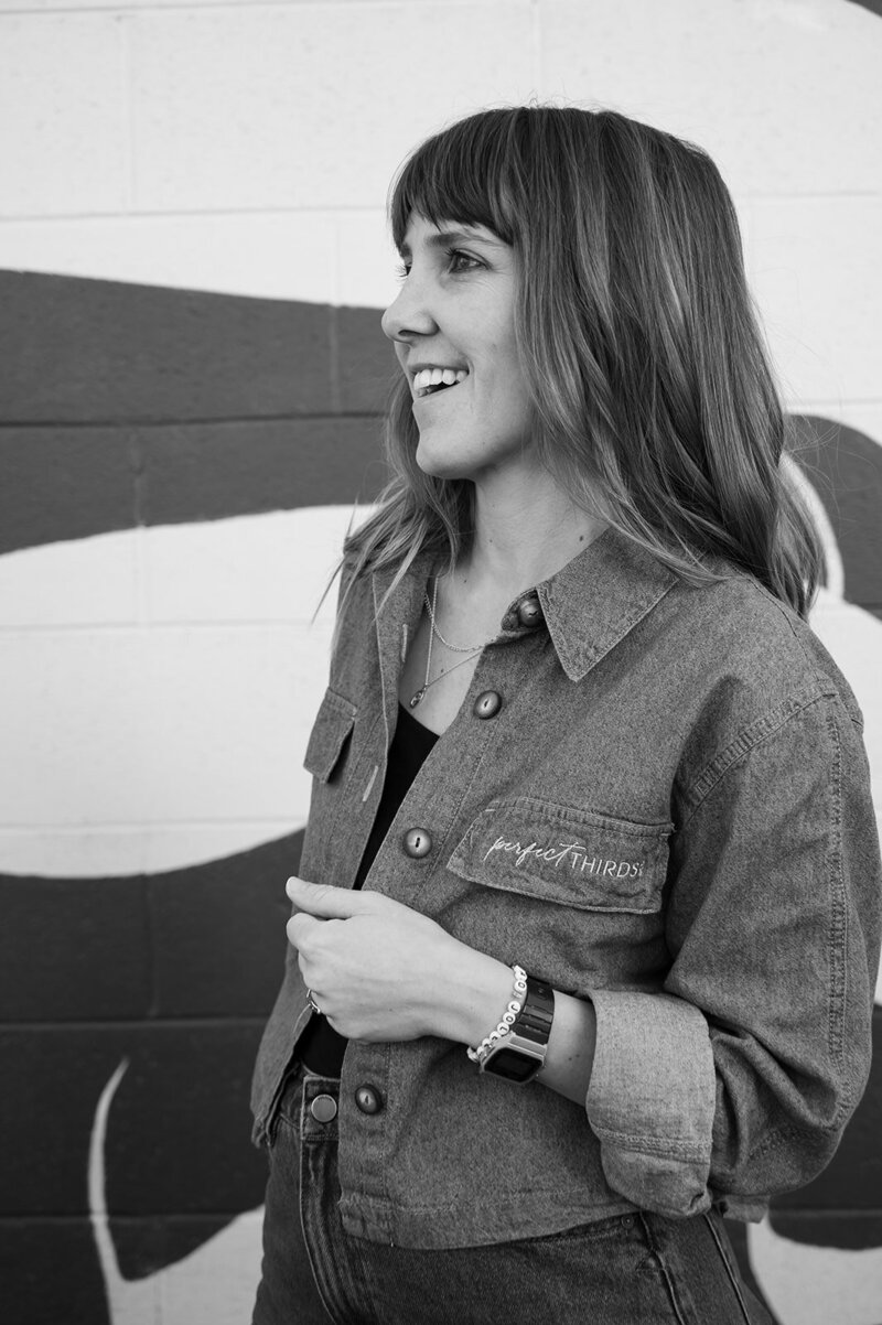 Boise wedding and event planner Alex smiles with one hand in her pocket while looking to the side.