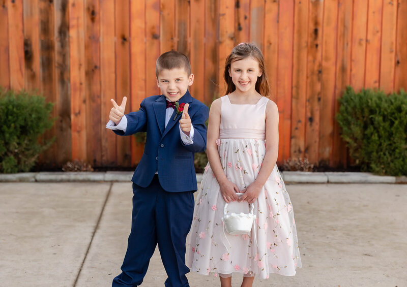 Adorable flower girl and ring bearer walking together during a wedding at Piazza Messina in Cottleville, MO, captured by Style & Grace Photography.