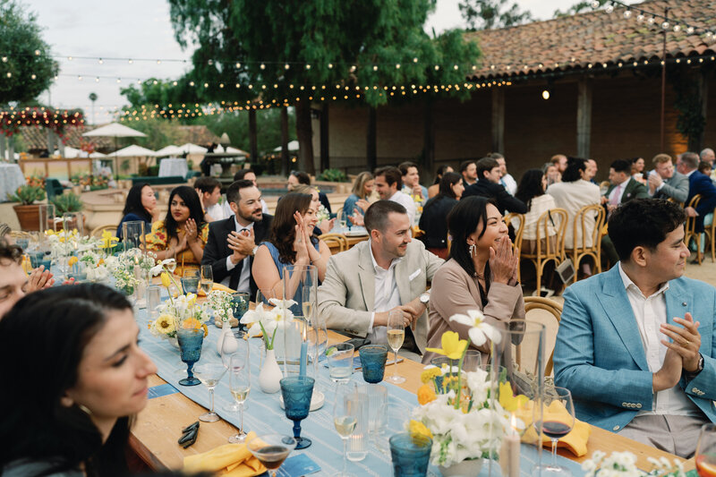 guests clap for the newlyweds entering the reception and share their first dance