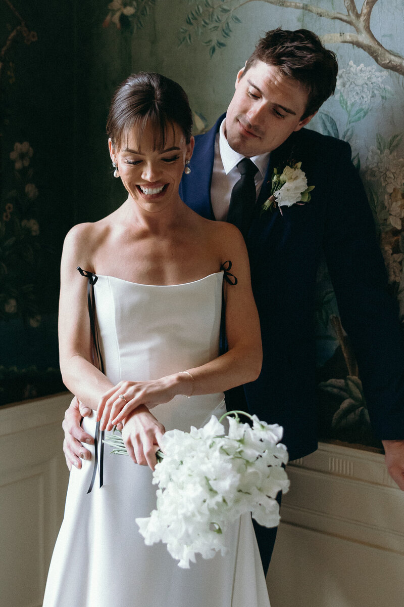 Vermont Wedding Photographer | Sincerely Liz Photography Documentary Wedding, Engagement, Elopement, Maternity and Newborn Photographer in New England | Bride smiling while holding her white bouquet and groom holds her waist