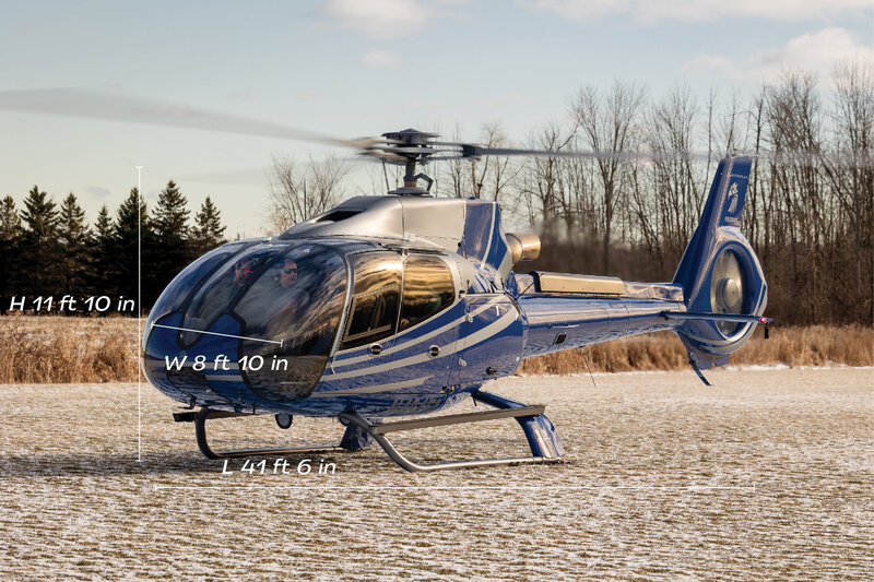 blue airbus ec130 b4 helicopter on grass with snow - elite helicopter services