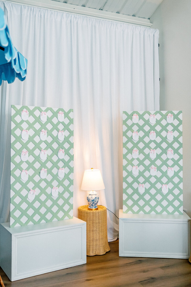 Minty green trellis style seating chart with oval name cards and pink satin bows, next to a rattan lamp stand and toile ceramic lighting for a spring wedding in Atlanta Georgia | Atlanta wedding photographer Emily Nicole Photography