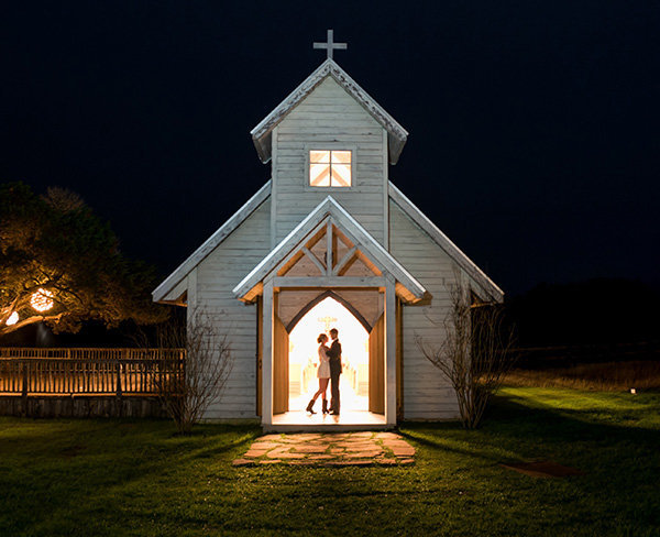 Destination wedding couple standing in the church doorway at night, at Twisted Ranch.