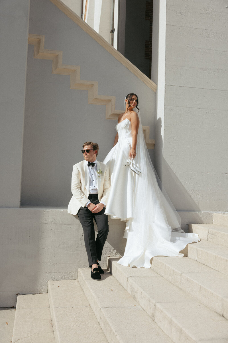 Couple portraits in downtown Saint Augustine, Florida. Custom Jack Sullivan wedding down, and white tuxedo jacket. Designed by The Eventful Gals. 
