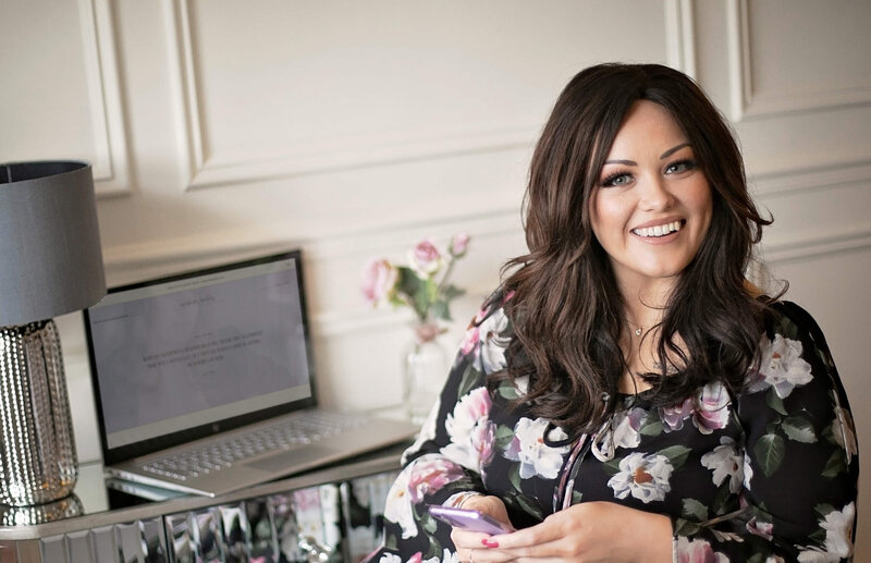 Beckie Rose, founder and lead designer at NorthRose Studio smiling and sitting at a desk