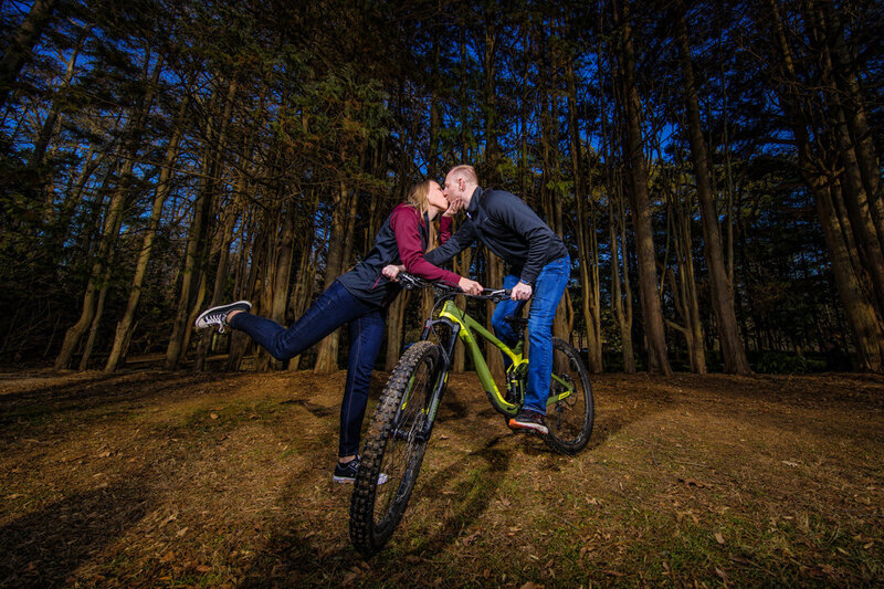 Adventure-seeking duo showing off their passion for mountain biking during their bold and out-of-the-box engagement session.