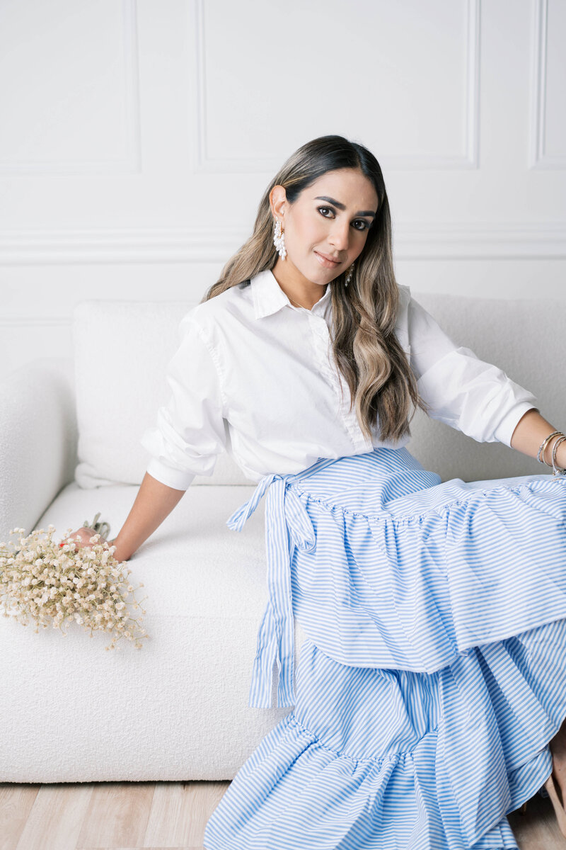 girl holding flowers while sitting in white couch