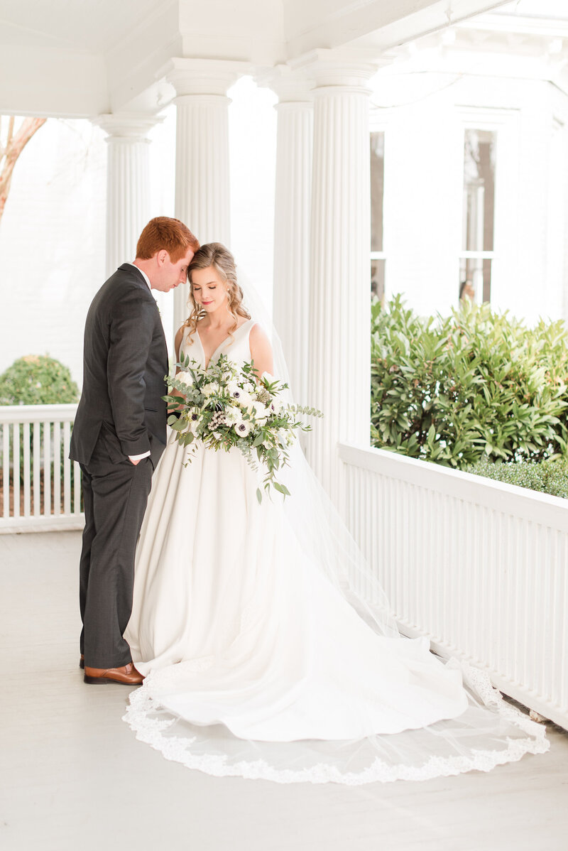 Portrait of newly married couple on the porch of McAlister-Leftwich-House in Greensboro, NC.