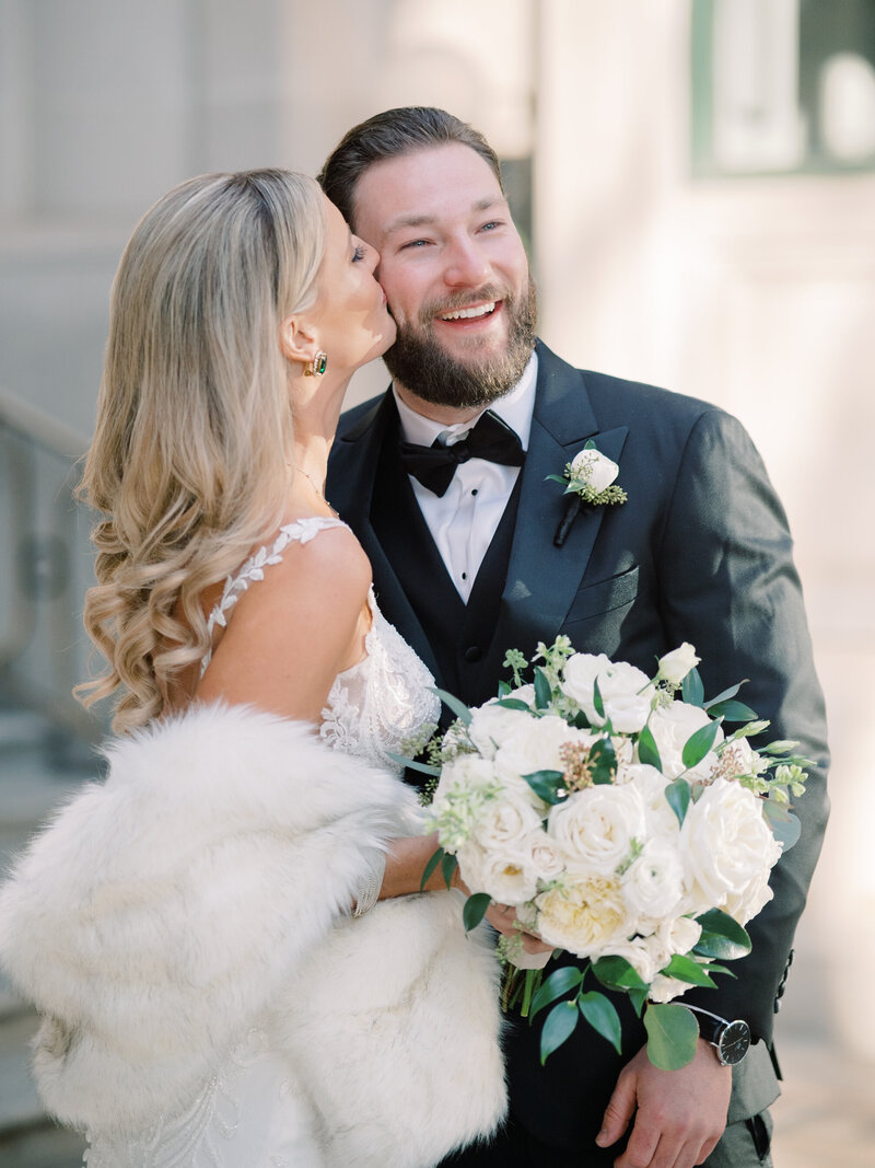 bride kissing her groom on the cheek at her washington dc wedding at the willard intercontinental by virginia wedding photographer omar and co