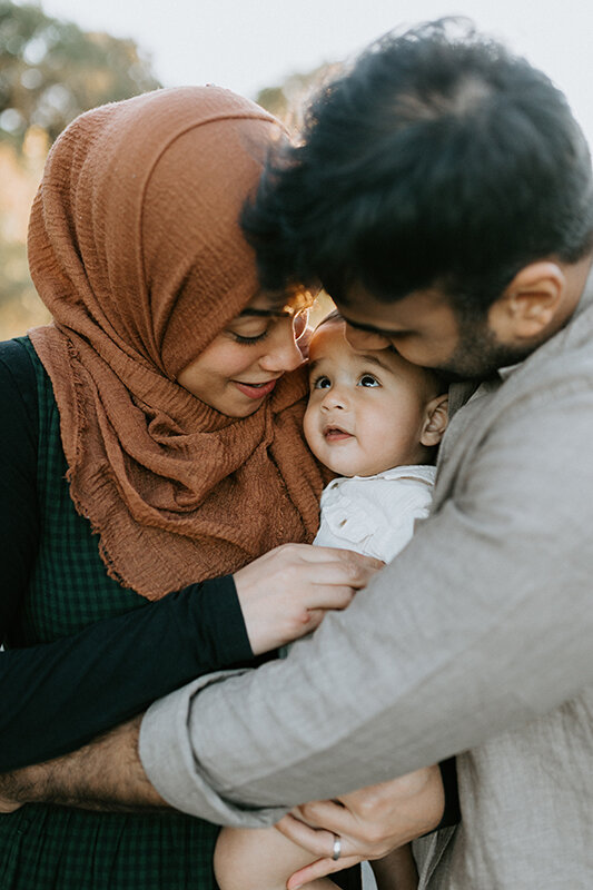 A father and mother hold their baby close during their family photos in Lafayette, Indiana. 