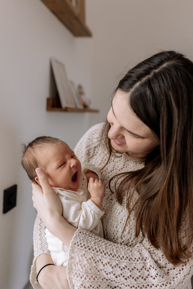 Mutter mit gaehnendem Baby auf dem Arm