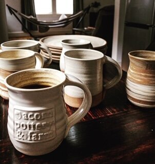 acorn pottery logo mugs on a table