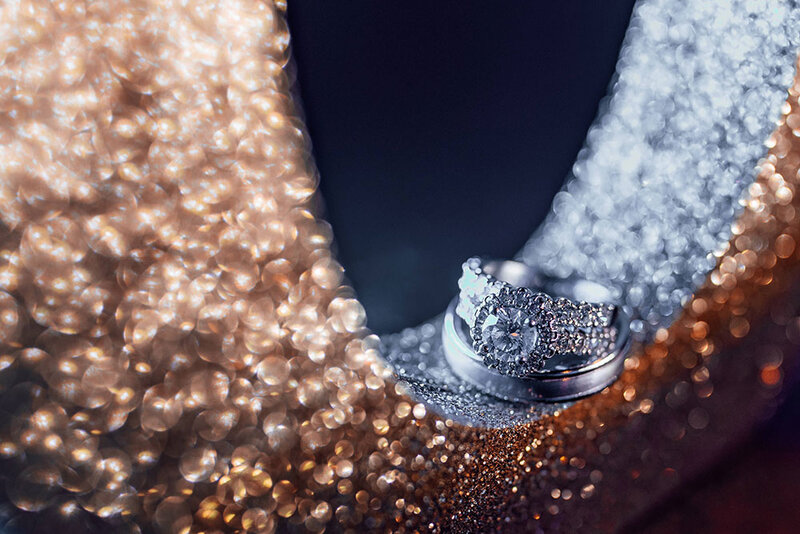 beautiful wedding rings sitting atop a sparking high heel