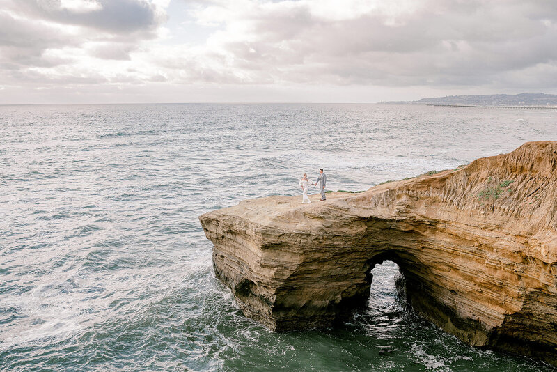 a couple walks out on the cliff at their elopement at Sunset Cliffs  in San Diego