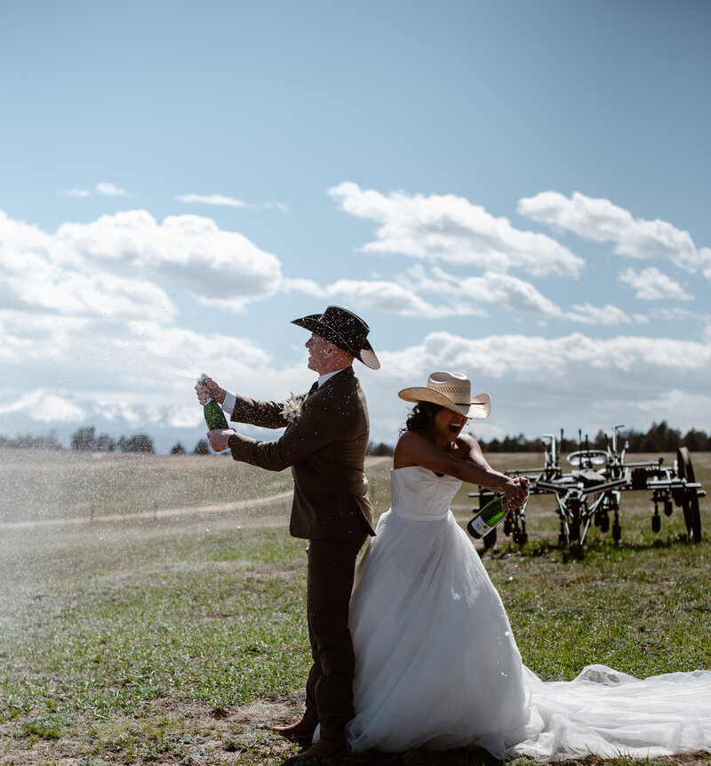 Bride & Groom pop champagne bottles after their ceremony on a Colorado Farm