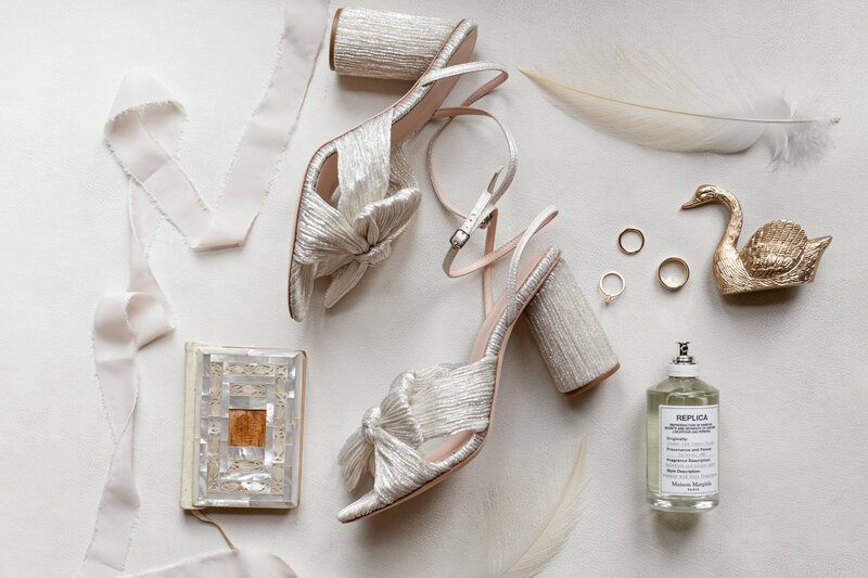 wedding day details with brides shoes, perfume, rings