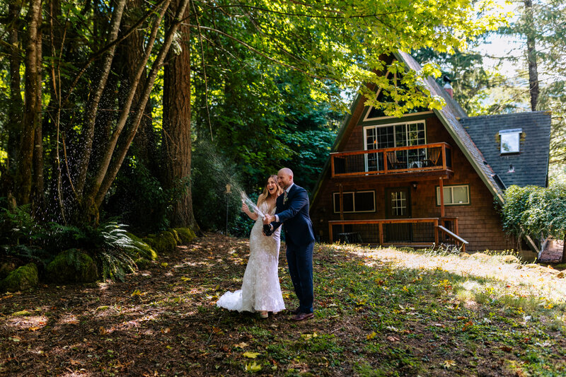 couple standing in front of an A frame cabin inthe forrest Oregon Coast elopement and wedding photographer