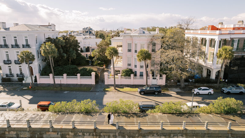 drone photo of The Battery with the pink house in the background and a bride and groom