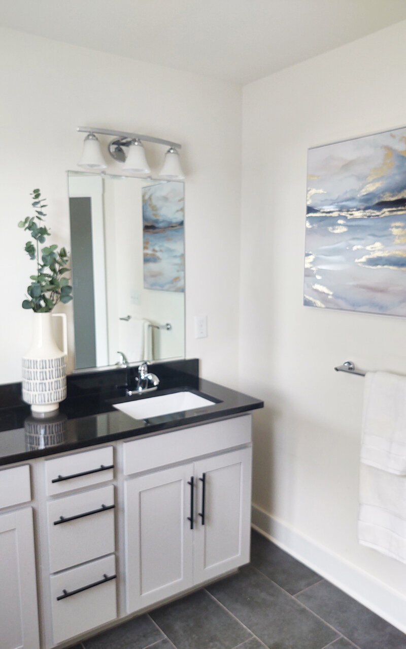 Vase of flowers and art near bathroom