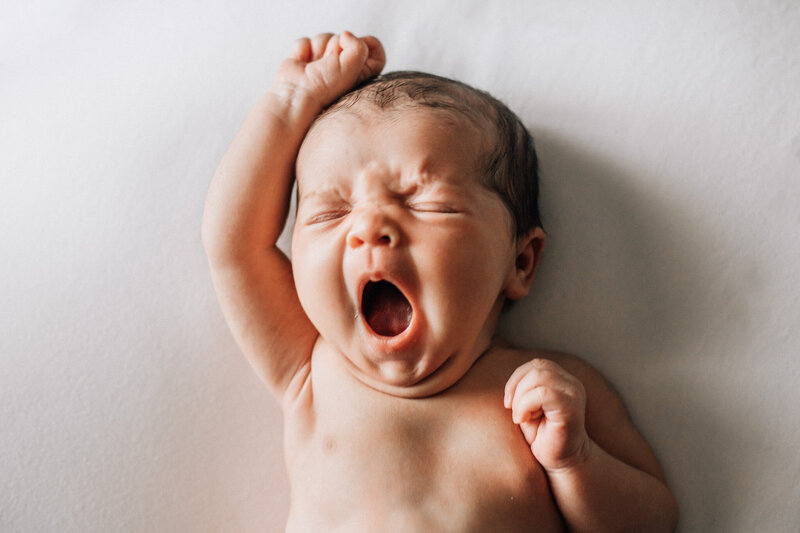 open eyed newborn in white with headband