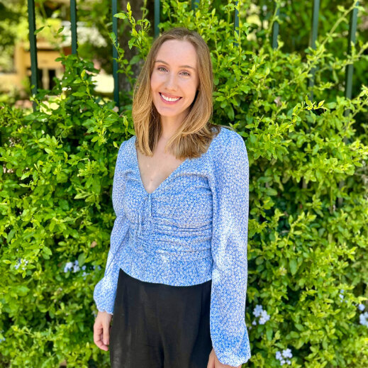 Expat Life Coach in front of a green bush