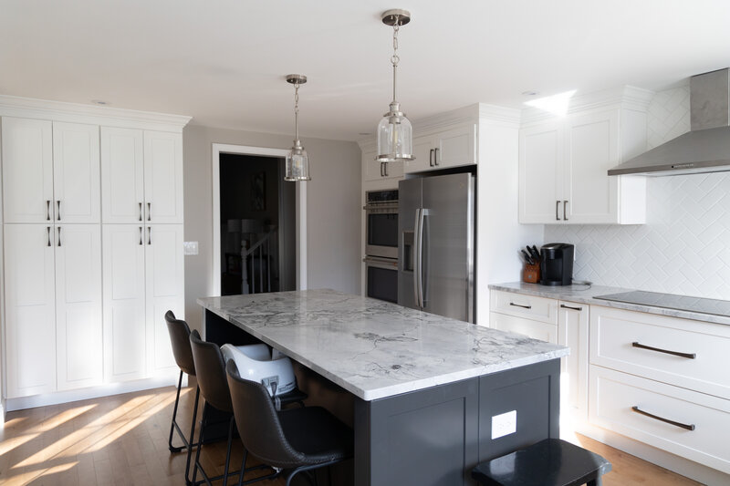 Complete Connecticut kitchen remodel with quartz countertops and white cabinets and a black island. 